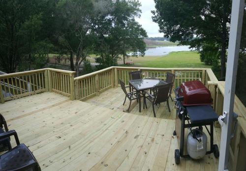 a wooden deck with a table and chairs on it at Keystone Direct Lake Front Cottage 2BR in Keystone Heights