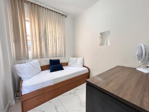 a small bedroom with a bed and a window at Apartamento de 3 quartos no setor Bueno na AV T 30 proximo da Videira in Goiânia