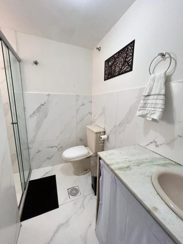 a white bathroom with a toilet and a sink at Apartamento de 3 quartos no setor Bueno na AV T 30 proximo da Videira in Goiânia