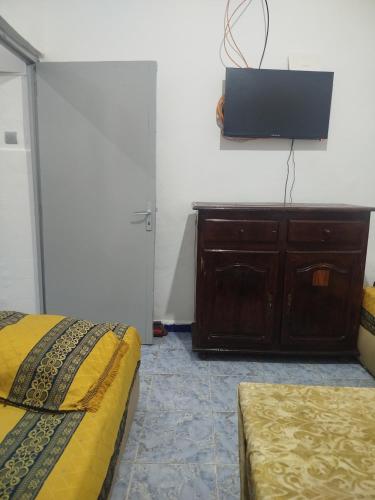 una camera con 2 letti e una TV a parete di Taghazout appartement z a Taghazout