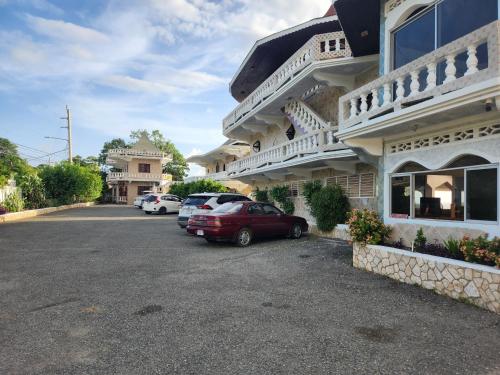 a red car parked in front of a building at Kaisers Sunset Hotel - Adults Only, Negril in Negril