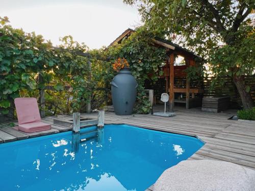 a pool with a vase sitting next to a wooden deck at Tiny House Nada Vineyard in Rakhat