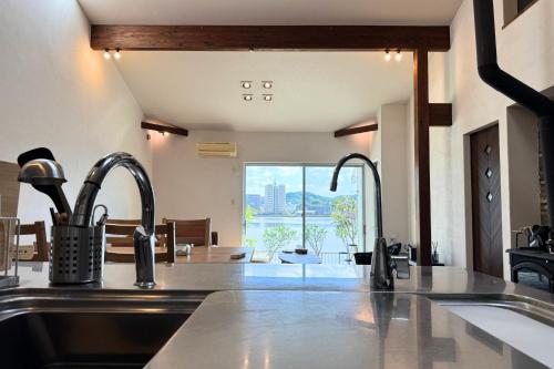 a kitchen with a sink and two faucets at Riverview唐津 in Karatsu