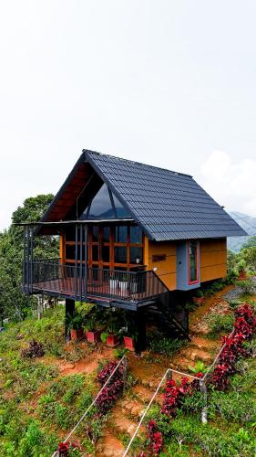 a small house on top of a hill with flowers at Mount Lux Villa in Devāla