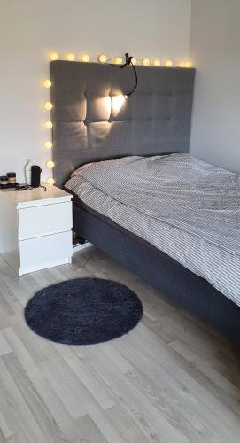 a bedroom with a bed with a night stand and a rug at Studio with sauna in the center in Laitila