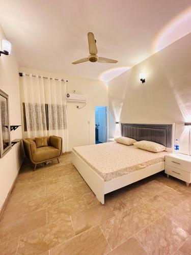 a bedroom with a bed and a ceiling fan at Apartment in Karachi near airport in Karachi