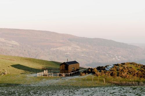 a small house on a hill with a mountain at Vega in Llangollen