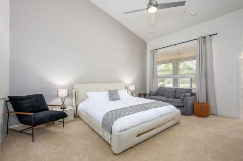 a white bedroom with a bed and a chair at Echo Ridge home in Scottsdale