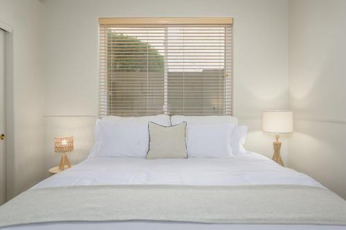 a bedroom with a white bed with a window at Echo Ridge home in Scottsdale