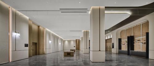 a hallway of a building with tables and chairs at Holiday Inn Kunshan East by IHG in Kunshan