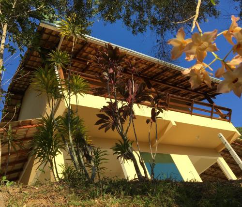a building with palm trees in front of it at Pousada Porto Belo in Porto Belo
