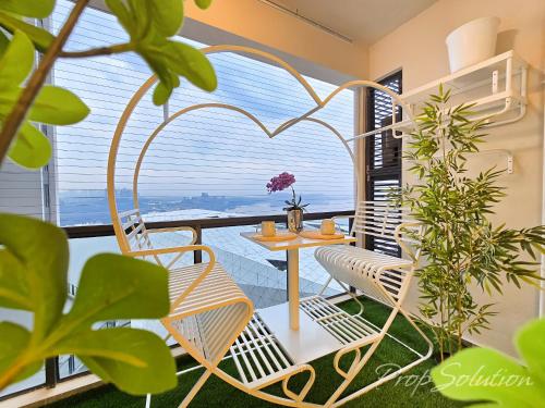 a balcony with a table and chairs and plants at Cozy Seaview Suite Johor Bahru CIQ in Johor Bahru