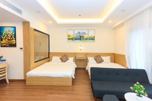 a hotel room with two beds and a couch at Căn Hộ FLC SEA TOWER Quy Nhơn View Biển Giá Rẻ in Quy Nhon