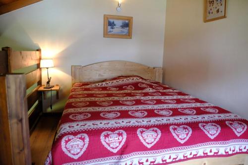 a bedroom with a red bedspread with hearts on it at Aigles 19 Bajeux Bât 2 in La Clusaz