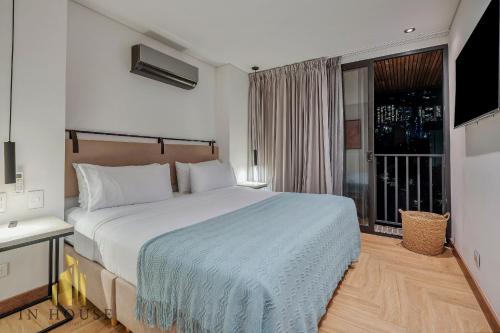 une chambre avec un grand lit et une fenêtre dans l'établissement Morph 1001 - Exclusive apt in Poblado/BBQ, à El Poblado