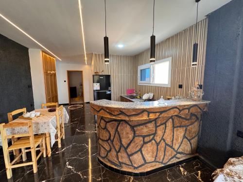 a kitchen with a large stone bar in a room at Le Relax 