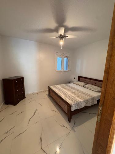 a bedroom with a bed and a ceiling fan at Le Relax 