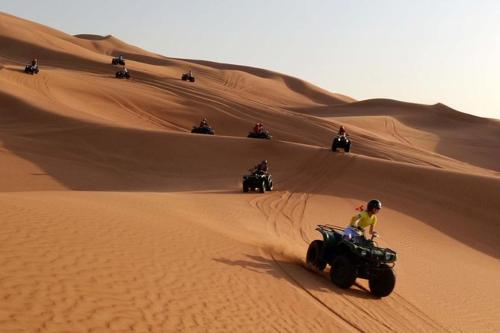 a group of people riding on atvs in the desert at Alghyamcamp in Muntarib