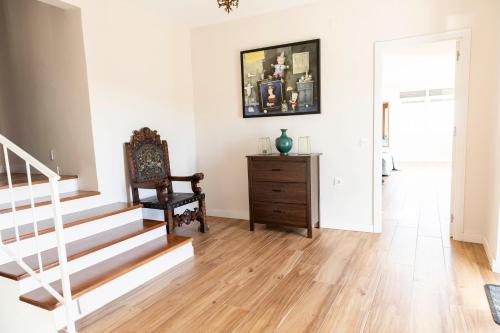 a living room with a staircase and a chair at Casa rural DOS ENCINAS in Andújar