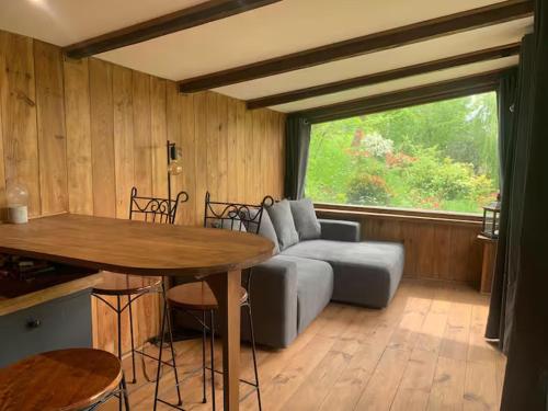a living room with a couch and a table at Le Châtaignier in Le Crestet
