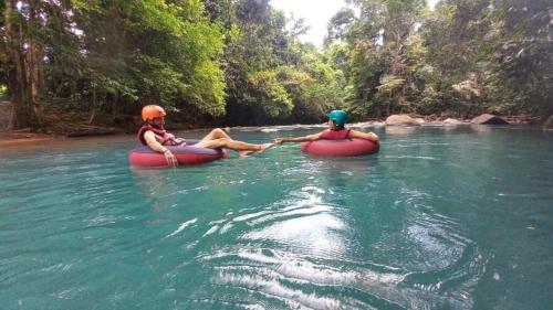 two people are riding in inflatable kayaks on a river at Garza del Sol Glamping Bromelia in San Rafael