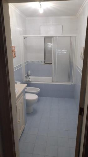 a white bathroom with a toilet and a sink at Santo Antonio 2 in Alenquer