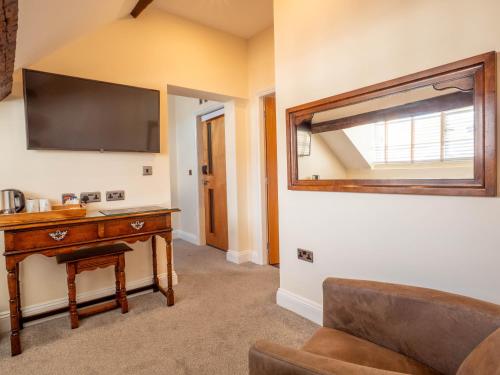 a living room with a tv and a table and a couch at The Black Boy Inn in Caernarfon