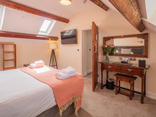 a bedroom with a bed and a desk and a mirror at The Black Boy Inn in Caernarfon
