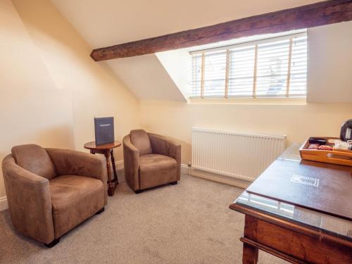 a living room with two chairs and a table and a window at The Black Boy Inn in Caernarfon