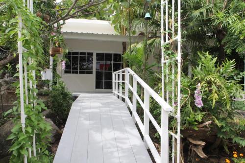 un sentiero bianco che conduce a una casa con delle piante di Homeku Guesthouse Room 4 Cozy Stay Close to Suvarnabhumi Airport a Lat Krabang