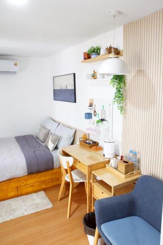 a bedroom with a bed and a desk and a table at Homeku Guesthouse Room 4 Cozy Stay Close to Suvarnabhumi Airport in Lat Krabang
