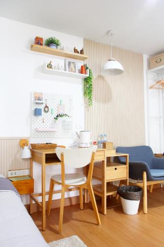 a living room with a table and a desk at Homeku Guesthouse Room 4 Cozy Stay Close to Suvarnabhumi Airport in Lat Krabang