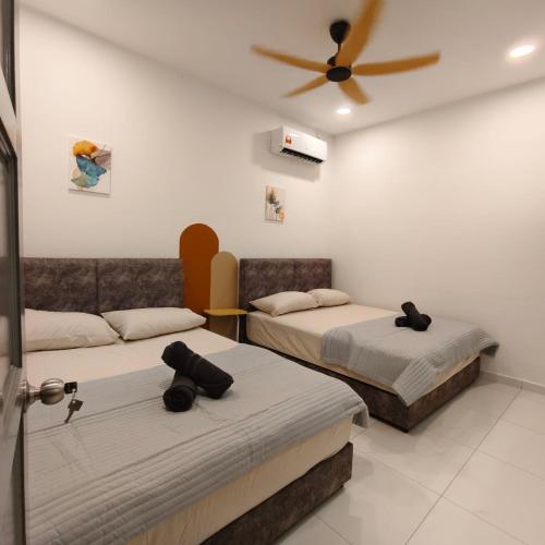 a room with two beds and a ceiling fan at D'Laman Muji 3R2B for 12 paxes in Kuantan