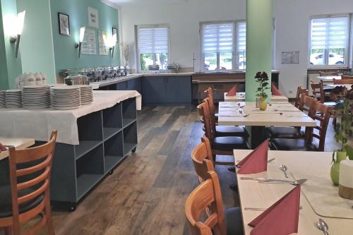 a dining room with tables and chairs in a restaurant at Garner Hotel Cottbus Süd by IHG in Cottbus