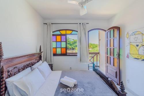 a bedroom with a bed and a stained glass window at Linda Casa em Cabo Frio PTB0105 in Peró