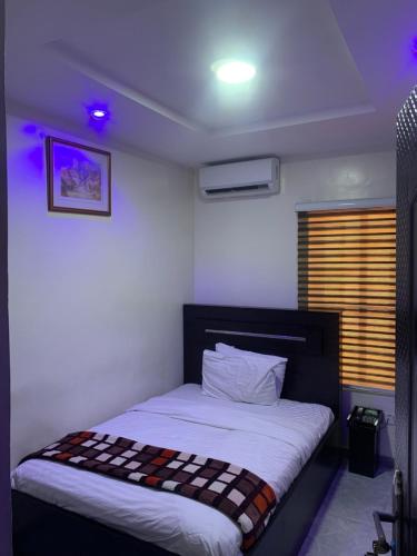 a bedroom with a bed in a room with purple lights at Cbox Lodge & Lounge in Lagos