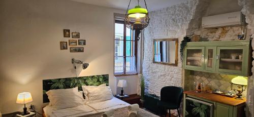 a bedroom with a bed and a desk with a chair at B&B Palace Basilico 1580. in Rovinj