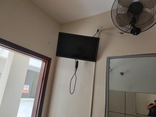 a flat screen tv hanging on a wall next to a mirror at Hotel Boa Vista in Assis