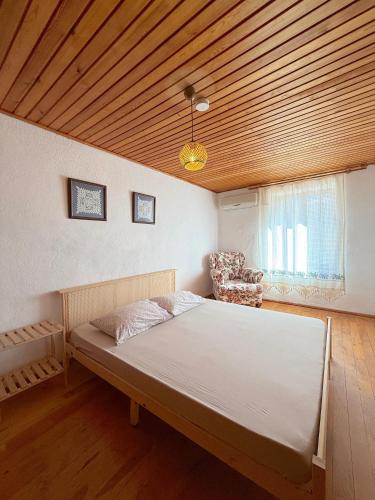 a large bed in a room with a wooden ceiling at Melisa Garden in Cunda