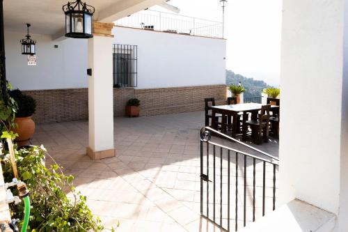 a patio with a table and chairs and a fence at Casa rural DOS ENCINAS in Andújar