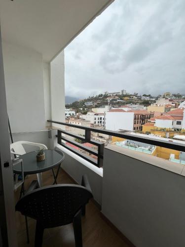 a balcony with a table and a view of a city at Toplage. Blick. Sauber. Günstig. Pool. Gepflegt in Puerto de la Cruz