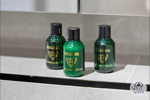 three green glass bottles sitting on a shelf at Free Parking - Next to Waitrose - Finchley 2Bed2BA in Finchley
