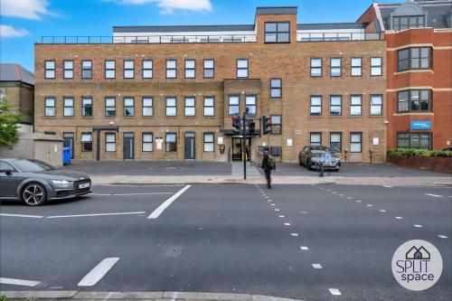 a person crossing a street in front of a building at Free Parking - Next to Waitrose - Finchley 2Bed2BA in Finchley
