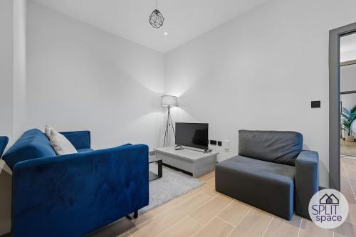 a living room with two blue couches and a tv at Free Parking - Next to Waitrose - Finchley 2Bed2BA in Finchley