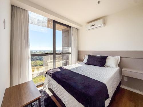 Un dormitorio con una cama y una ventana grande. en Vista livre, suíte de luxo, Apartamento de Luxo, en Brasilia