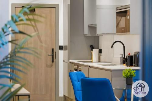 a kitchen with two blue chairs and a sink at Free Parking - Next to Waitrose - Finchley 2Bed2BA in Finchley