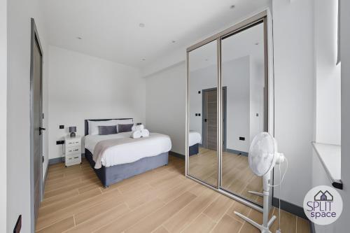 a white bedroom with a bed and a mirror at Free Parking - Next to Waitrose - Finchley 2Bed2BA in Finchley
