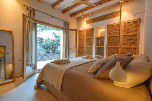 une chambre avec un grand lit avec une grande fenêtre dans l'établissement Son Estiu, à Sóller