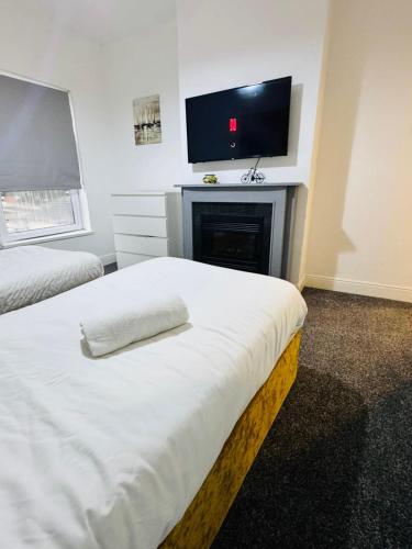 a bedroom with a bed with a fireplace and a flat screen tv at Walsall Comfort Home 3Bedroom Retreat Sleeps 6 in Bescot