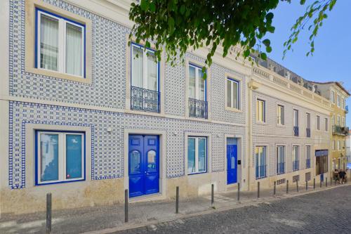 a building with blue doors on a street at InLoveApartments - Luxury in Alfama in Lisbon